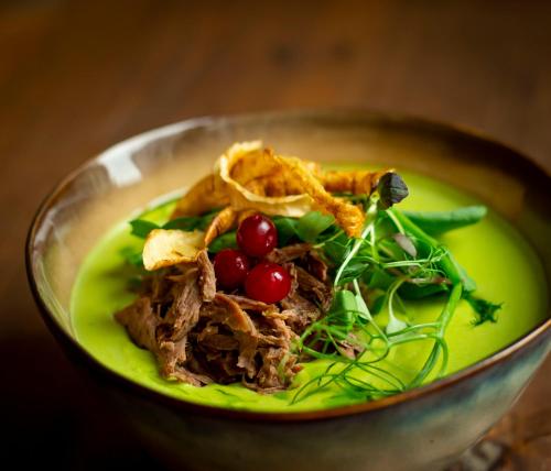 a plate of food with meat and vegetables in a bowl at Meriton Old Town Garden Hotel in Tallinn