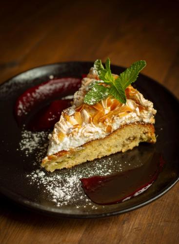 a piece of cake on a black plate with chocolate at Meriton Old Town Garden Hotel in Tallinn