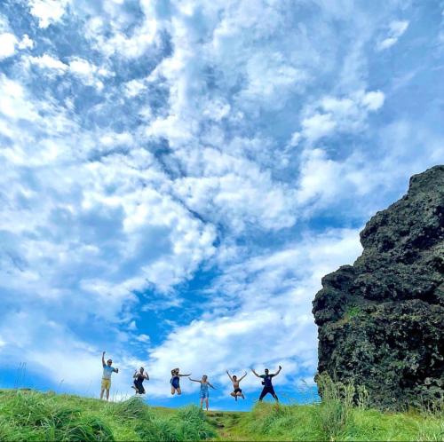 a group of people jumping in the air on the beach at 海街日記民宿 Ocean Diary Hostel in Green Island