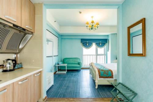 a blue room with a bed and a kitchen at Dalian Hong Xi Yuan Apartment Wanda Plaza in Dalian