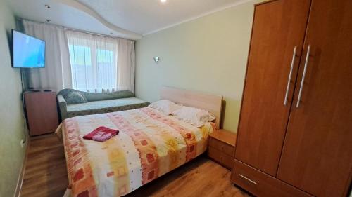 a small bedroom with a bed and a dresser at Sporta 2 in Daugavpils