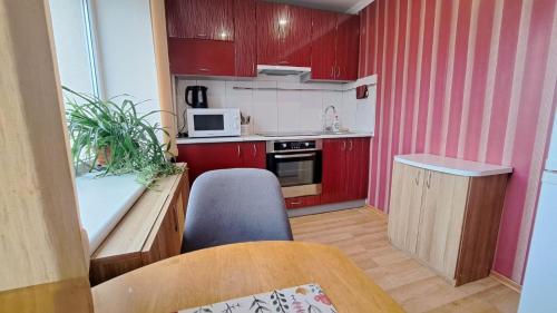 a small kitchen with red cabinets and a table at Sporta 2 in Daugavpils