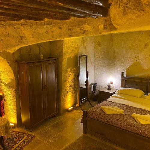 a bedroom with a bed in a stone room at Ürgüp Inn Cave Hotel in Urgup