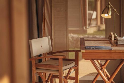 a wooden chair sitting next to a desk with a laptop at Aladdin Luxury Camp Phuket in Phuket