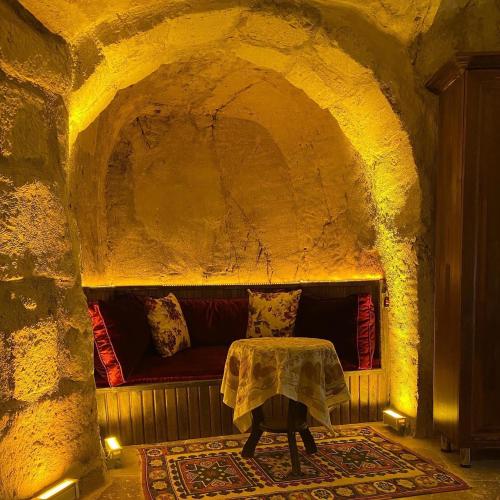 a living room with a couch in a stone tunnel at Ürgüp Inn Cave Hotel in Urgup