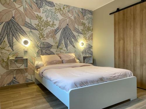 a bedroom with a bed with a floral wallpaper at Gite du Pavillon in Rocroi