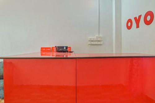 a red counter with a phone on top of it at SPOT ON Jp Guest House in Kāhārpāra