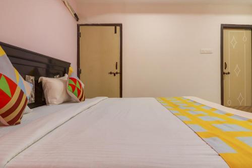 1 dormitorio con 1 cama blanca grande con almohadas coloridas en OYO Home RBS Homes, en Maula Ali