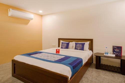 UpalにあるCapital O 10225 Wild Wings Hotel Near Omni Hospital Lane Nagole main roadのベッドとデスクが備わるホテルルームです。
