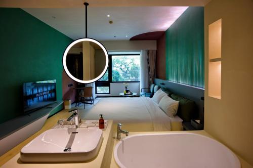 La salle de bains est pourvue d'un lavabo, d'un lit et d'un miroir. dans l'établissement Zhi Resort Beijing, à Pékin