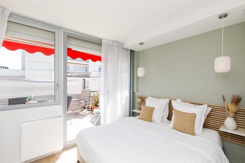ein Schlafzimmer mit einem weißen Bett und einem großen Fenster in der Unterkunft XXL 2 beds with XXL terrace next to Martinez Hotel in Cannes