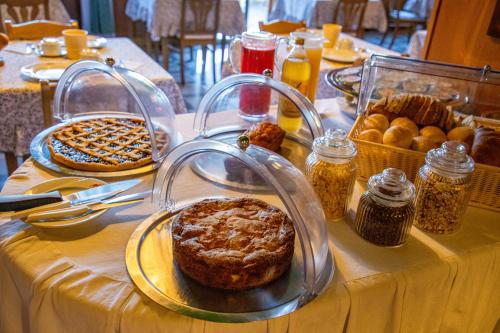 una mesa con pan y otros alimentos. en Hostellerie Le Lievre Amoureux, en Valpelline