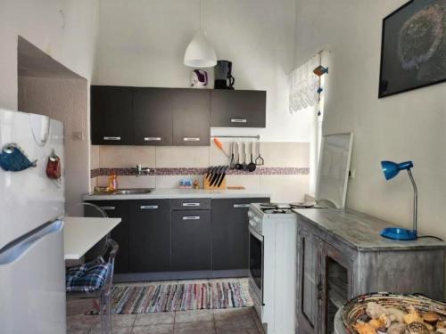 a kitchen with black cabinets and a white stove at Apartment Dolores in Cres