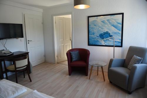 um quarto com uma cama, uma secretária e cadeiras em Altes Weingut an der Vogtei em Senheim