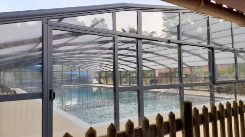 una piscina vista a través de una ventana de cristal en Mobilhome proche du Puy du Fou, en La Boissière-de-Montaigu