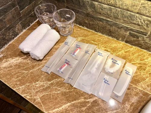 a table with three toothbrushes and towels on it at Ashley Tang Menteng Jakarta in Jakarta