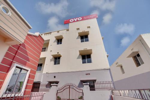 a white building with a red sign on top at OYO Satya Homes in Khandagiri