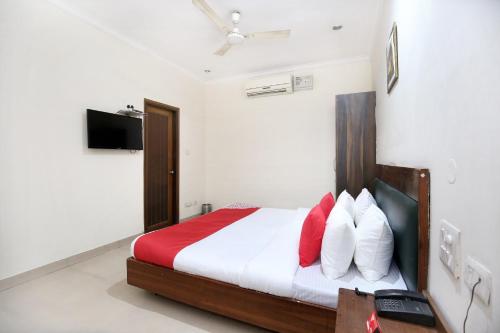 a bedroom with a bed with red and white pillows at Super OYO Hotel Supreme in Chandīgarh