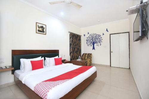 - une chambre dotée d'un grand lit avec des oreillers rouges et blancs dans l'établissement Super OYO Hotel Supreme, à Chandigarh