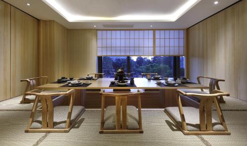 a dining room with a table and chairs and a window at Kempinski Hotel Xiamen in Xiamen