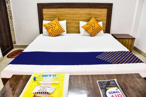 a bed with yellow and blue pillows in a room at SPOT ON City Tower Inn in Jāmul