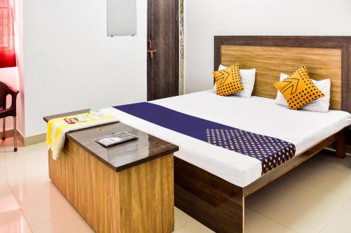 a bedroom with a bed with a wooden headboard at SPOT ON City Tower Inn in Jāmul