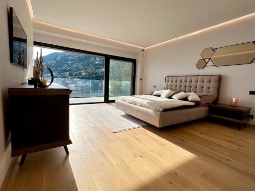 a large bedroom with a bed and a large window at Villa Folie in Roquebrune-Cap-Martin