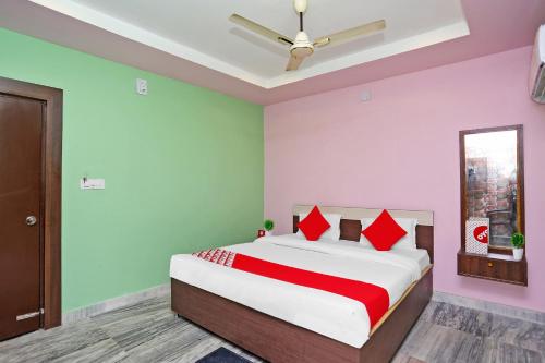 a bedroom with a bed with red and green walls at Capital O Hotel Aryan in Khandagiri