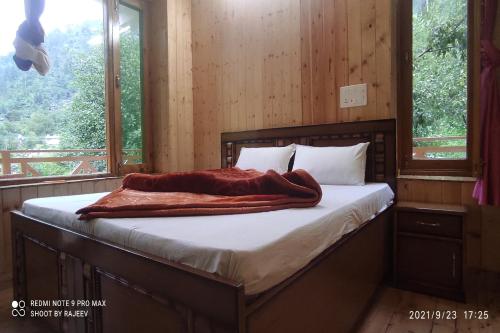 A bed or beds in a room at OYO Kamal Guest House Tirthan