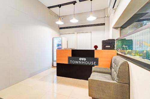 a showroom with a couch and a sign on the wall at Townhouse 999 INN24 Airport in Chennai