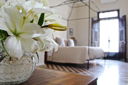 a vase with white flowers on a table in a living room at The Diplomat Boutique Hotel in Mérida