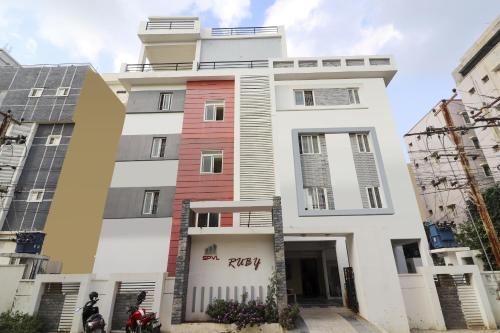 OYO Ruby Grand Inn في Kondapur: مبنى أبيض عليه لافتة بيتزا