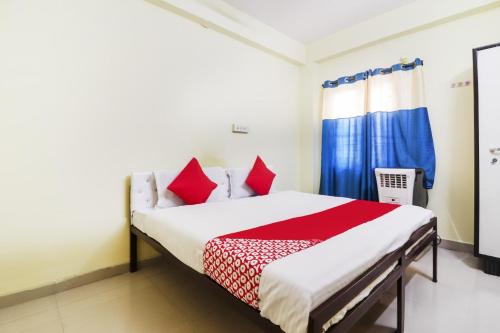 1 dormitorio con 1 cama con almohadas rojas en OYO Ruby Grand Inn, en Kondapur