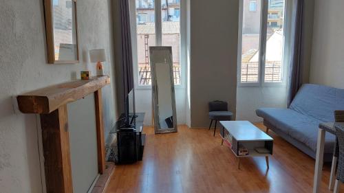 アジャクシオにある**** VERY CENTRAL Ajaccio 36 rue Fesch, cosy flat in city center pedestrian street, up to 4 people ****のリビングルーム(青いソファ、テーブル付)