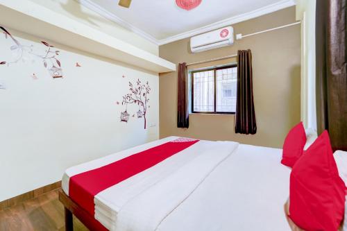 a bedroom with a large bed with red pillows at Flagship Hotel Sai Residenci in Lonavala