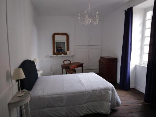 une chambre avec un lit, un miroir et un bureau dans l'établissement La Maison de Famille, à Jumilhac-le-Grand