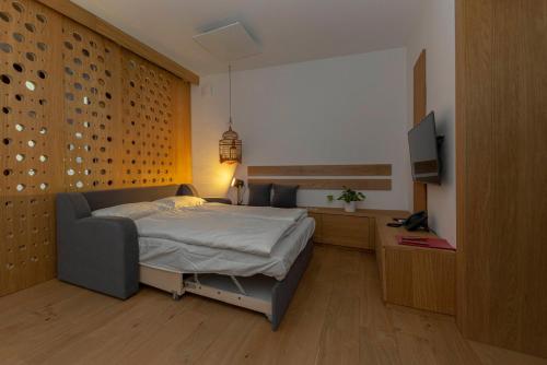 a bedroom with a bed and a flat screen tv at Apartma Jenkova rezidenca in Kranj