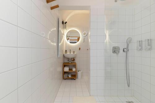 a white bathroom with a shower and a sink at Apartma Jenkova rezidenca in Kranj