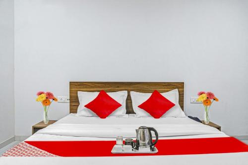 a hotel room with a bed with red pillows at OYO Hotel Weekend Rooms in Surat