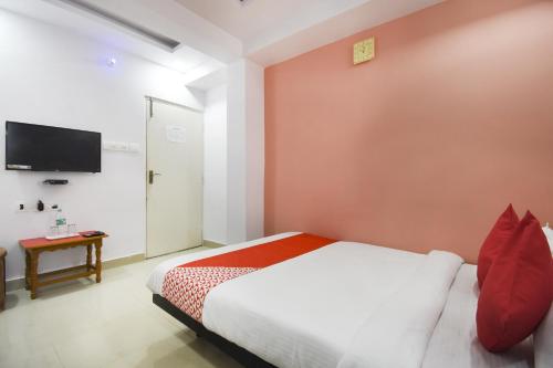 a bedroom with a bed and a tv on a wall at Airport Comfort Stay in Garui