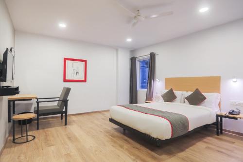 a bedroom with a bed and a desk and a chair at Townhouse 143 Hotel Royal Garden Near park Street Mullick bazar crossing in Ballygunge