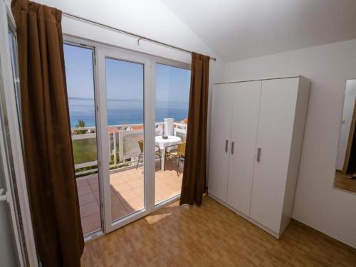 a room with a balcony with a view of the ocean at Apartments Bandalo in Podstrana
