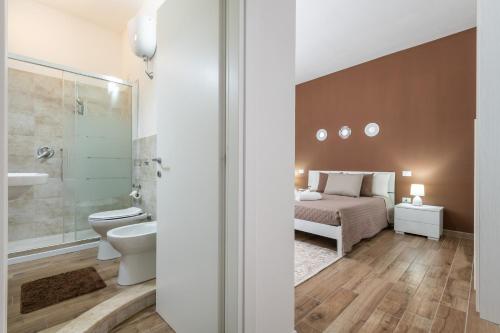 una camera con letto, servizi igienici e lavandino di Villetta Mattia a Pula