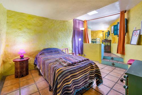 um quarto com uma cama e uma mesa com um candeeiro em El Nido holiday cottage with pool em Órgiva