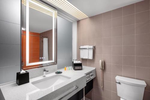 a bathroom with a sink and a toilet and a mirror at RIHGA Royal Laguna Guam Resort in Tamuning