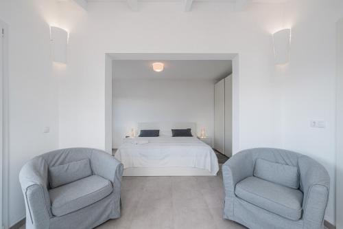 Un dormitorio con dos sillas y una cama dentro. en Es Raco Sa Rapita, en Llucmajor