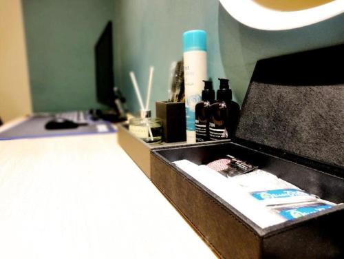 a bathroom counter with a box of cosmetics and a lamp at 27 Hotel in Anyang