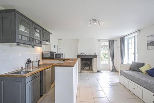 - une cuisine avec des armoires noires et un canapé dans la chambre dans l'établissement Appartement de charme dans un château à 5 min d'Honfleur, à Gonneville-sur-Honfleur