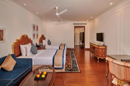 a hotel room with two beds and a couch at MAYFAIR Lake Resort in Raipur
