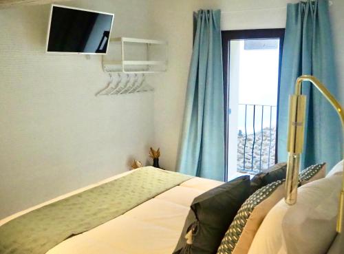1 dormitorio con 1 cama y TV en la pared en La Casa Rebonita PICCOLA en Candelario